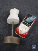 A miniature dress maker's dummy and a tin plate model of a VW Beetle