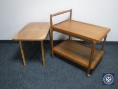 A teak two-tier serving trolley together with a folding walnut table