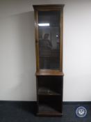 A late Victorian narrow glass door display cabinet fitted with shelves beneath