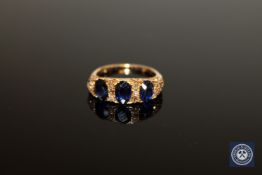 A yellow gold ring set with rose cut diamonds and three synthetic sapphires