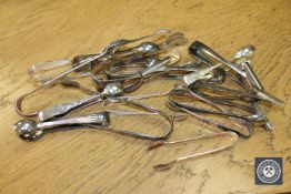 A large collection of antique and later sugar tongs (Q)