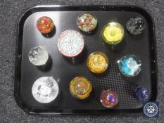 A tray containing twelve glass paperweights