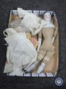 An early 20th century china doll together with a small quantity of clothing