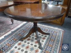 An inlaid mahogany Regency style circular pedestal dining table