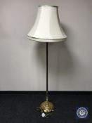 A brass standard lamp with shade