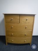 A contemporary oak bowfronted five drawer chest