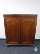 An early twentieth century narrow mahogany double door cabinet