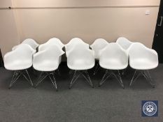 Ten Eames style white plastic armchairs on metal legs