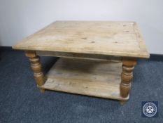 An antique stripped pine two-tier coffee table