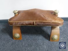 A camel stool with an animal hide saddle