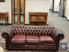 A Burgundy leather three seater Chesterfield settee,