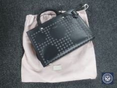 A black leather Radley handbag with carrying strap and dust cover