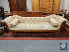 A Victorian style mahogany framed settee with bolster cushions,