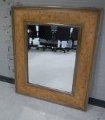 A contemporary carved floral framed mirror