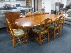 An inlaid yew wood twin pedestal dining table with leaf,