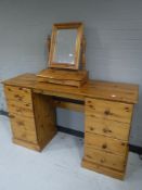 A pine kneehole dressing table fitted eight drawers with mirror