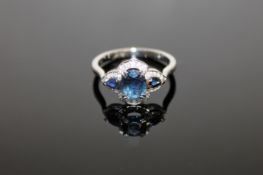 A 14ct white gold sapphire and diamond ring, an oval-cut deep-blue sapphire weighing 0.