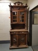A Victorian heavily carved oak glazed bookcase with barley twist supports, width 101 cm.