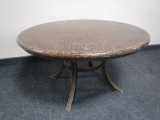 A circular copper topped table on metal base