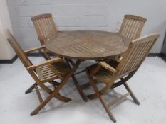 A circular teak folding patio table together with four chairs