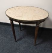 An oval mahogany marble topped occasional table with metal mounts
