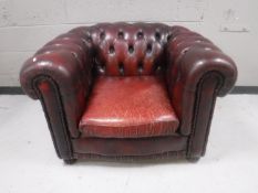 An oxblood buttoned leather Chesterfield style club armchair