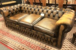 A Chesterfield style tan buttoned leather three seater bed settee, length 217 cm.