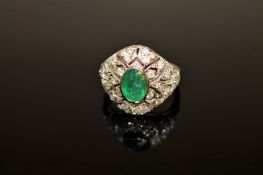 An 18ct white gold emerald and diamond ring, the oval-cut medium-green emerald weighing 0.