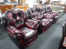 A three-piece oxblood buttoned leather lounge suite