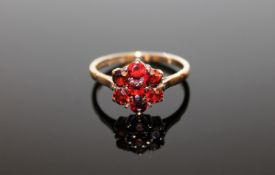 A 9ct gold flower head garnet ring, size O.