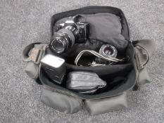 A camera bag containing two Canon cameras and lens