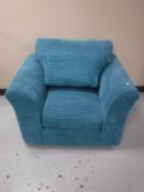 An armchair upholstered in a turquoise fabric