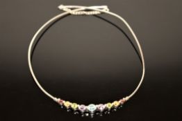 A silver necklace set with semi-precious stones; amethyst, peridot, topaz,