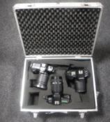 An aluminium camera case containing three Nikon cameras with lenses