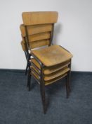 A set of four mid 20th century wood and tubular metal stacking school chairs