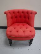 A Victorian style bedroom chair upholstered in a red buttoned fabric