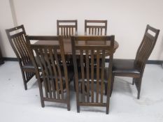 A circular stained pine pedestal kitchen table with leaf together with six rail back chairs