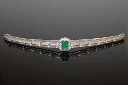 A lady's fancy bracelet set centrally with an emerald cut green paste,