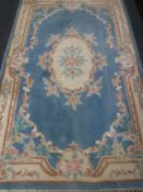 A fringed woollen Chinese rug on blue ground 148 cm x 240 cm