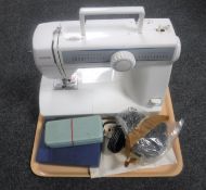 A Toyota electric sewing machine with foot pedal and accessories together with a boxed hip flask