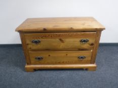 A pine two drawer chest with metal drop handles