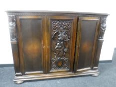 A continental stained beech triple door sideboard with carved panel door