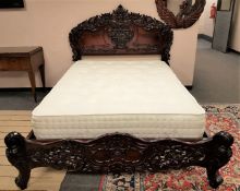 An impressive heavily carved hardwood 5 ' bed frame with Giltedge interior,