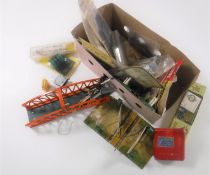 A box containing a collection of vintage railway accessories including tin plate crossing,