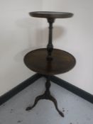 A mahogany two-tier wine table on tripod base
