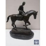 A bronze figure of a horse and jockey on marble base