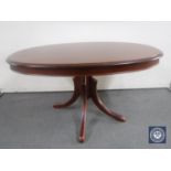 A reproduction oval pedestal coffee table