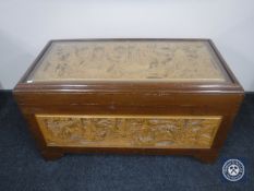 A glass topped carved camphor wood box