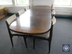 An oval oak extending dining table with two leaves and eight single chairs in beige fabric