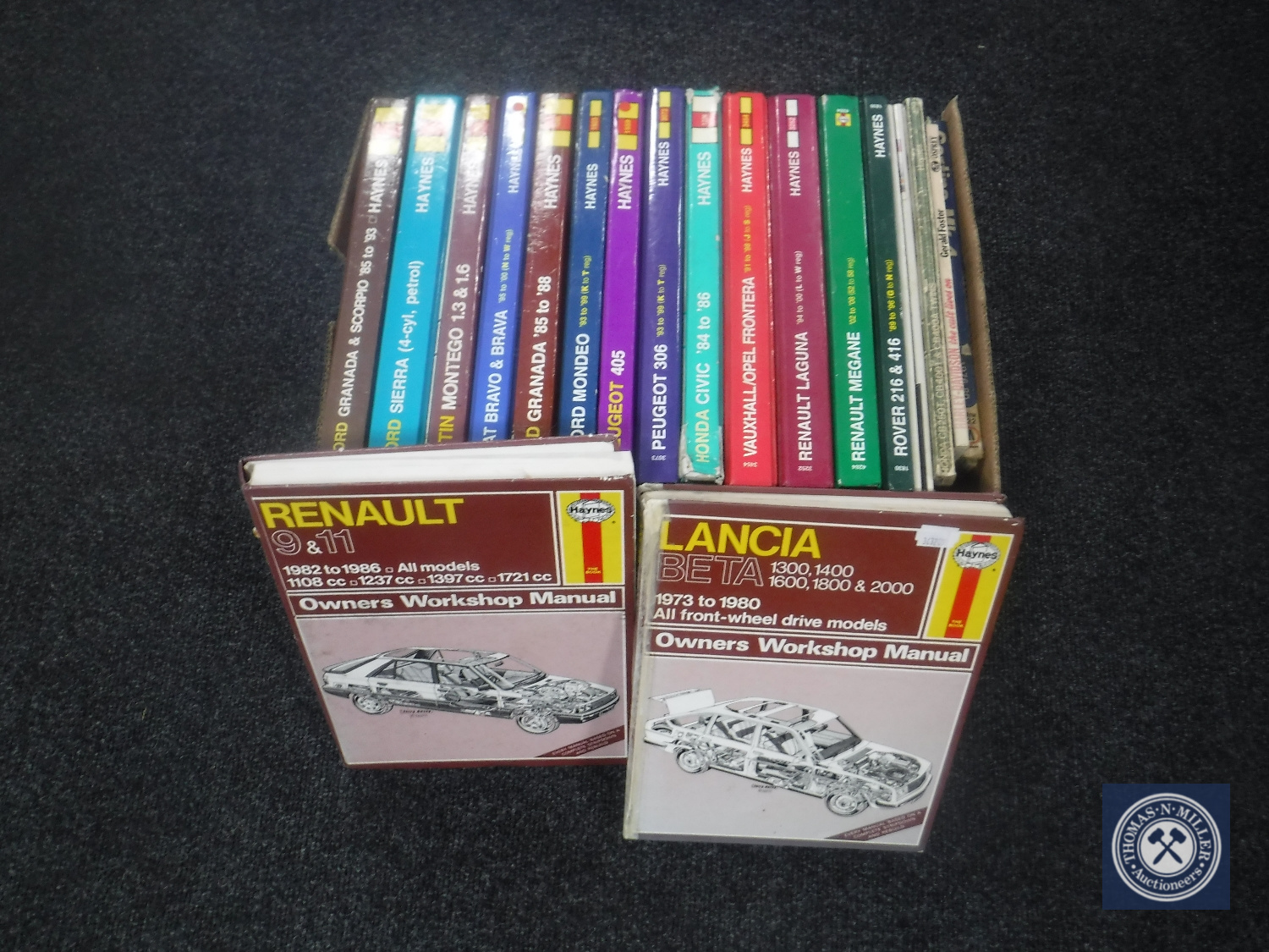 A box of Haynes car manuals and Owners workshop manuals